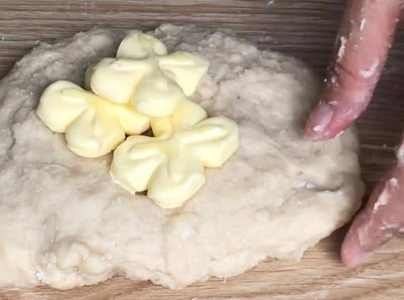 Nhồi được 15 phút thì cho thêm bơ lạt vào và tăng tốc nhồi bột bánh.
